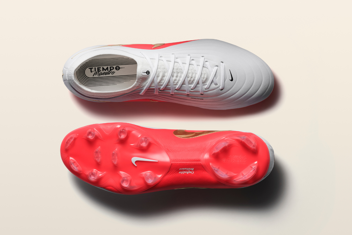 Изглед отгоре на светлосива футболна обувка Nike Tiempo Legend със стелка Tiempo Maestro, заедно с изглед на яркочервената ѝ подметка с конични шипове и бяло лого.