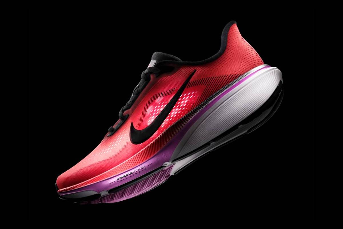 Мъжка обувка за бягане Nike Air Zoom Pegasus 42 в коралов цвят, погледната под ъгъл. Моделът показва детайли от подметката Air Zoom, черното лого на Nike и масивната олекотена междинна подметка в бяло, сиво и лилаво на черен фон.