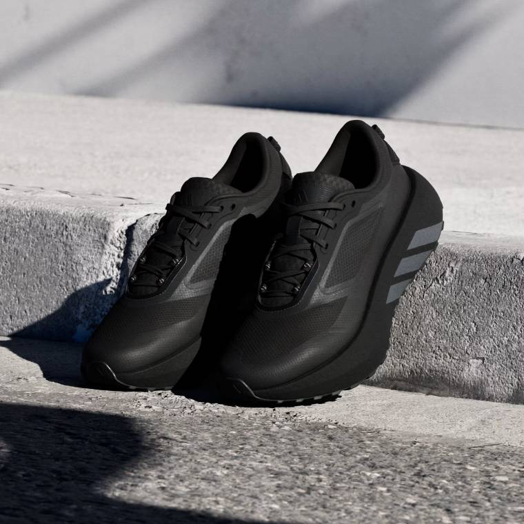 Мъжки маратонки за бягане Hyperboost ATR в изцяло черен цвят, заснети на градски бордюр.