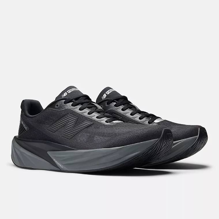 Изглед отпред-странично на чифт черни маратонки за бягане New Balance FuelCell Rebel с тъмносива подметка. 