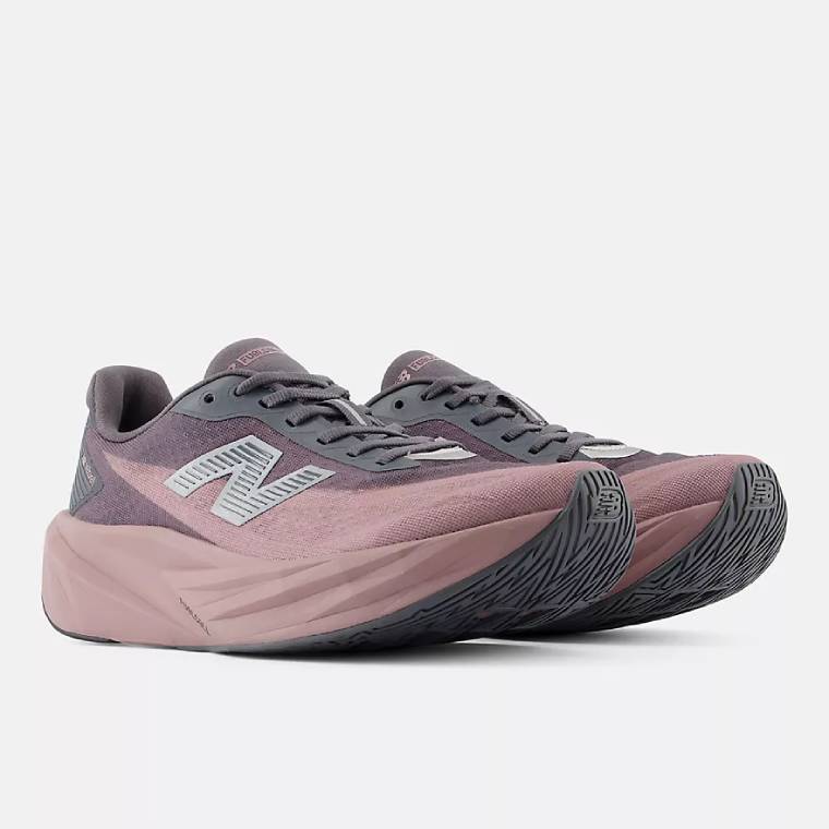 Изглед отпред-странично на чифт пепеляворозови маратонки New Balance FuelCell Rebel със сиви детайли. 