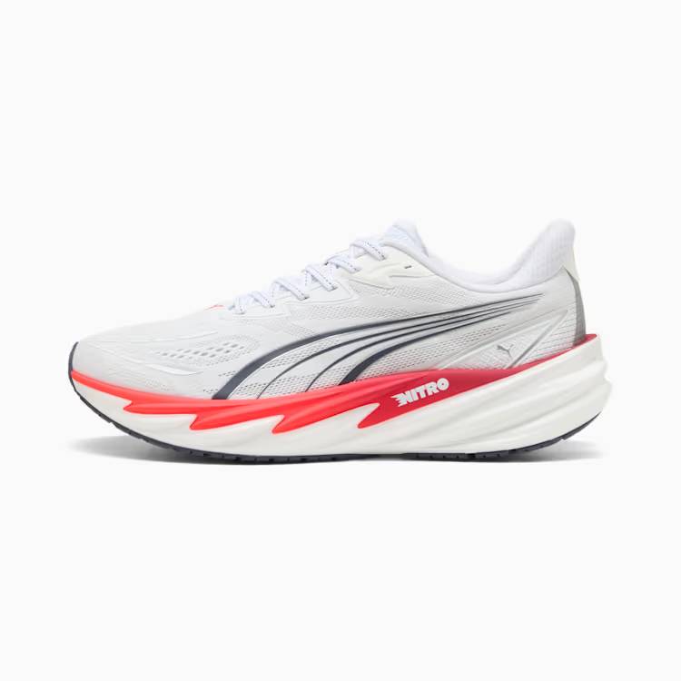 Лява спортна обувка Puma Velocity Nitro 5 в бял цвят, заснета странично от външната страна на бял фон. Изображението показва дишаща бяла мрежеста горна част, тъмна емблема Puma Formstrip и амортизираща бяла подметка с червено-оранжев детайл и надпис NITRO.